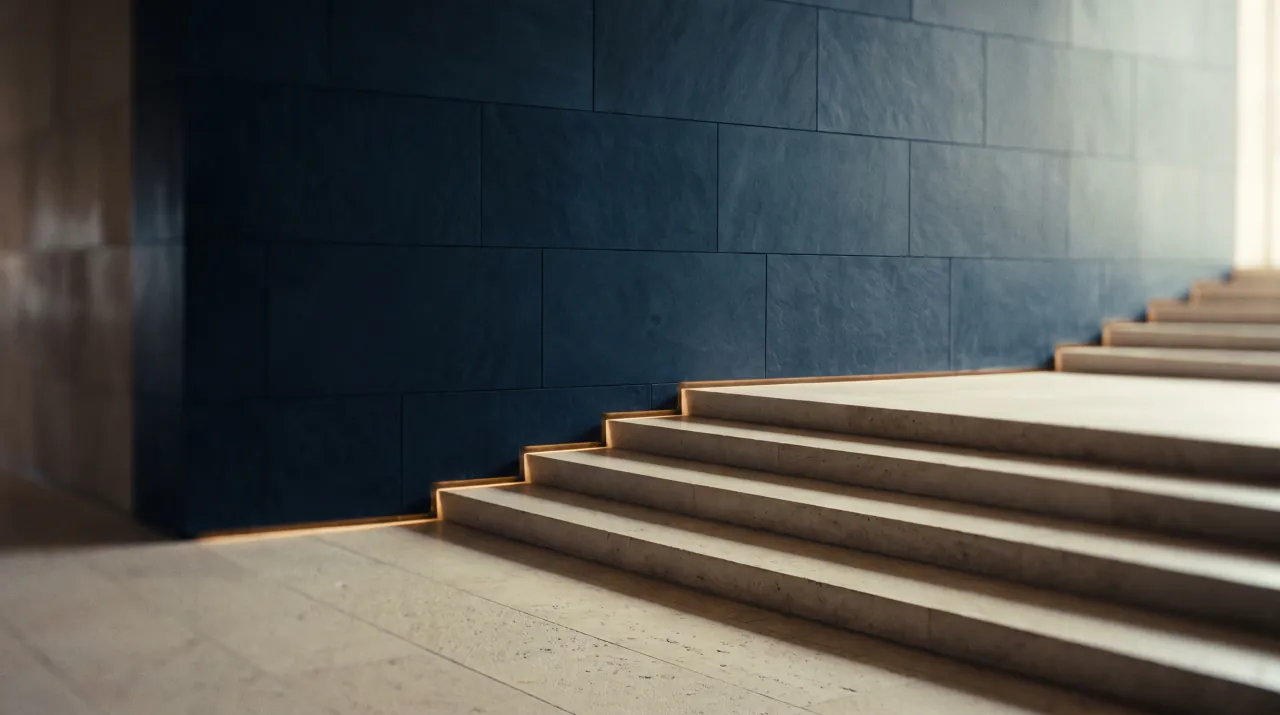 Limestone steps rising beside a navy stone wall in soft daylight